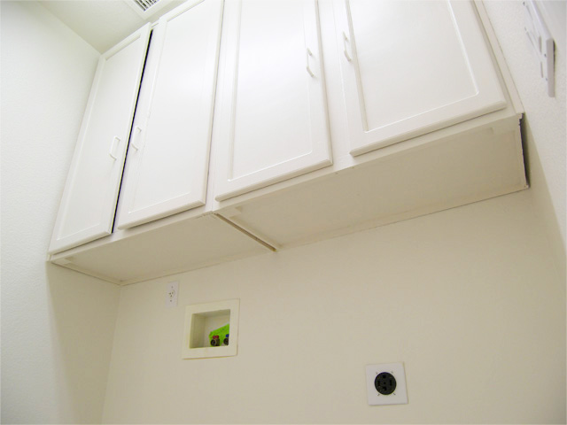 Inside laundry room with cabinets